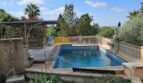 Rechteckiger Pool mit Steinumrandung, Pergola und Gartenblick auf einer Finca bei Inca, Mallorca.