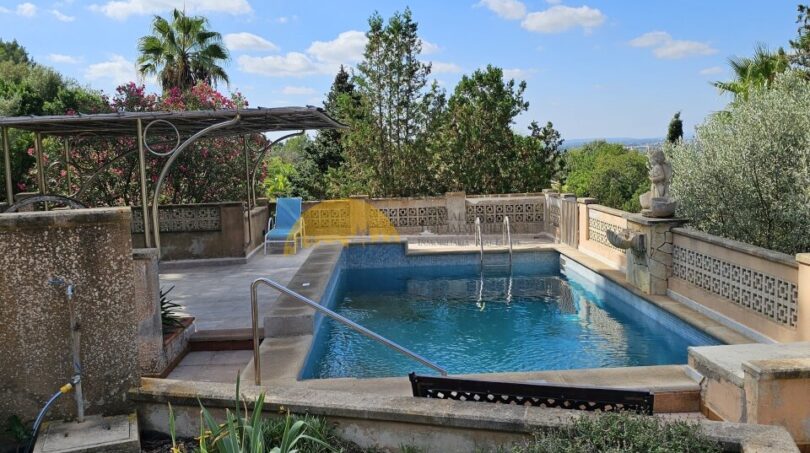 Rechteckiger Pool mit Steinumrandung, Pergola und Gartenblick auf einer Finca bei Inca, Mallorca.