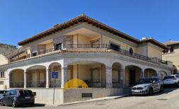 Exterior view of a two-story townhouse in Inca with arcades, balconies and Mediterranean architecture.