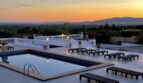 Infinity-Pool mit Sonnenliegen bei Sonnenuntergang, Blick über Marratxí bis zu den Bergen.