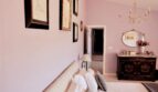 Elegantes Schlafzimmer mit Lila-Wänden, antikem Kommode, Kronleuchter und Kunstwerken in Villa Marratxí