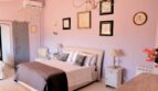 Elegantes Schlafzimmer in Rosa mit Doppelbett, Kronleuchtern und Kunstgalerie in Villa Marratxí