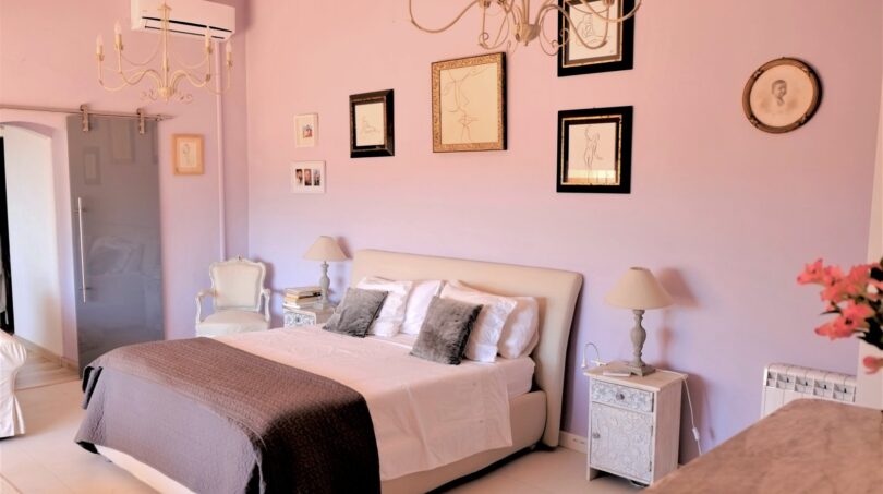 Elegantes Schlafzimmer in Rosa mit Doppelbett, Kronleuchtern und Kunstgalerie in Villa Marratxí