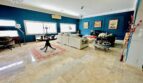Elegantes Wohnzimmer mit Marmorboden, blauen Wänden, weißen Sofas und Gemälden in Villa Marratxí