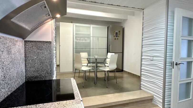 Offene Küche mit Granitarbeitsplatte und erhöhtem Essbereich in modernem Haus in Marratxí