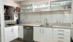 Moderne weiße Küche mit Granitarbeitsplatte, Geschirrspüler und Milchglas-Oberschränken in Marratxí-Immobilie