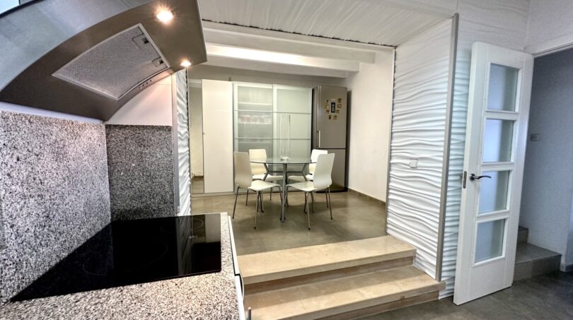 Moderne Küche mit Granitarbeitsplatte und erhöhtem Essbereich in exklusiver Villa in Marratxí