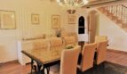 Elegantes Esszimmer mit Glasstisch, Kronleuchter und Treppe in Luxusvilla Marratxí