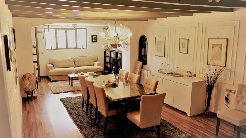 Elegantes Esszimmer mit Kronleuchter, Holzbalkendecke und angrenzendem Wohnbereich in Marratxí
