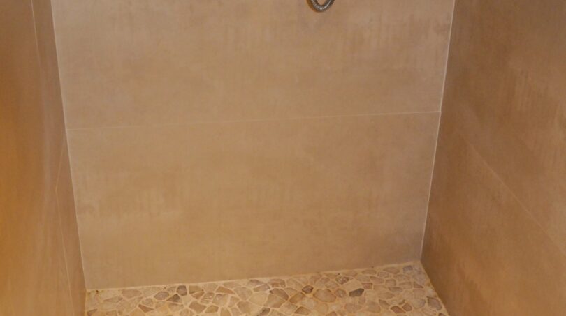 Bodenebene Dusche mit Kieselsteinboden und Thermostatkrahn in edler Luxusvilla in Marratxí