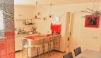Moderne Küche mit roter Kücheninsel und Barhockern in exklusiver Villa in Marratxí