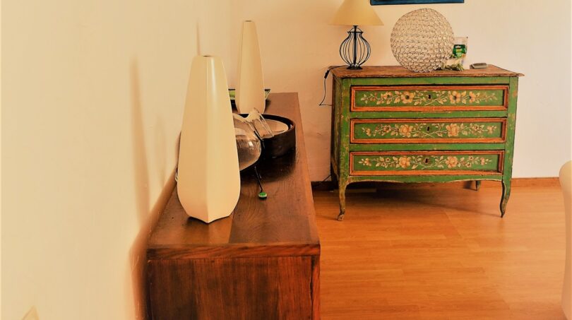 Eleganter Flur mit antikem grünen Kommode, Holzkonsole und Wandleuchter in Luxusvilla in Marratxí
