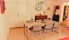 Elegantes Esszimmer mit modernem Glastisch, Designerstühlen und dekorativer Wanduhr in Marratxí-Villa