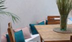 Sonnige Terrasse mit Holztisch, Stühlen und Bank mit bunten Kissen in Erdgeschosswohnung Palma de Mallorca