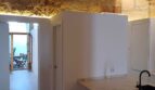 Moderne Küche mit Marmortresen, Natursteinwand und Holzbalkendecke in Erdgeschosswohnung Palma