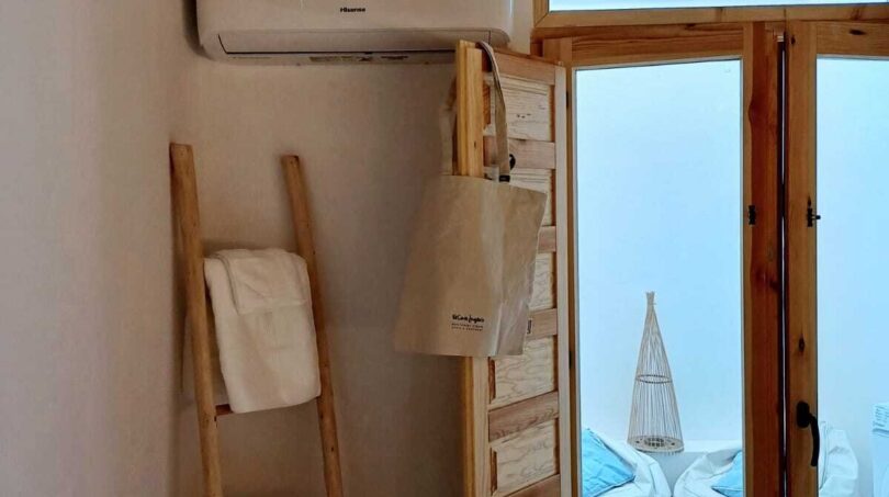 Zimmer mit Klimaanlage, Handtuchleiter und Holztür zum Außenbereich mit Sitzsäcken in Palma-Wohnung