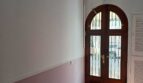 Eingangsbereich der Erdgeschosswohnung in Palma mit elegantem Rundbogenportal aus Holz und Terrakottaboden.