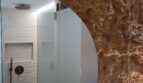 Modernes Badezimmer mit Regendusche und rustikaler Natursteinwand in Erdgeschosswohnung Palma