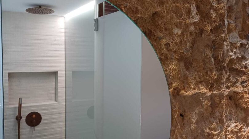 Modernes Badezimmer mit Regendusche und rustikaler Natursteinwand in Erdgeschosswohnung Palma