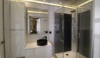Modernes Badezimmer mit schwarzem Aufsatzwaschbecken, Glasdusche und indirekter LED-Beleuchtung in Duplex-Wohnung Palma