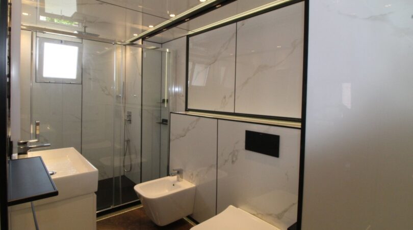 Modernes Bad mit Glasdusche, Bidet, WC und Marmorfliesen in kernsanierter Duplex-Wohnung Palma