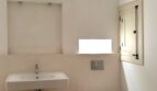 Modernes Badezimmer mit wandmontierten WC und Waschbecken, Mikrozementverkleidung und Fensterläden in Palma de Mallorca