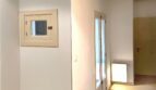 Heller Flurbereich mit Holzdielenboden, kleinem Wandfenster und Durchgang zu weiteren Zimmern der renovierten Wohnung