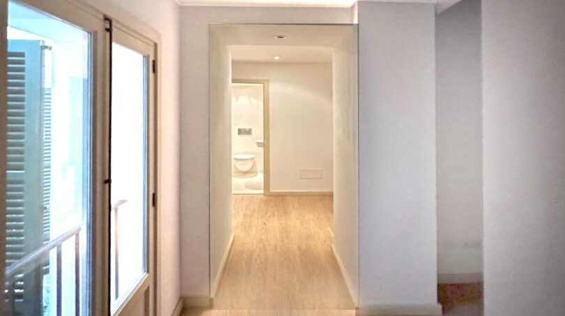 Heller Flur mit Holzboden und Blick ins Bad in renovierter 3-Zimmer-Wohnung in Palma de Mallorca