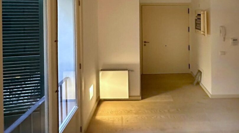 Heller, leerer Wohnraum mit Holzboden, Balkonzugang und Meerblick in renovierter Wohnung in Palma de Mallorca