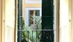 Balkon mit grünen Fensterläden und Palmenblick im mediterranen Innenhof, renovierte Wohnung Palma de Mallorca