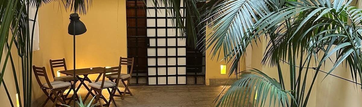 Elegante corte interior del apartamento en Palma con palmeras, suelo de piedra natural y acogedora zona de estar
