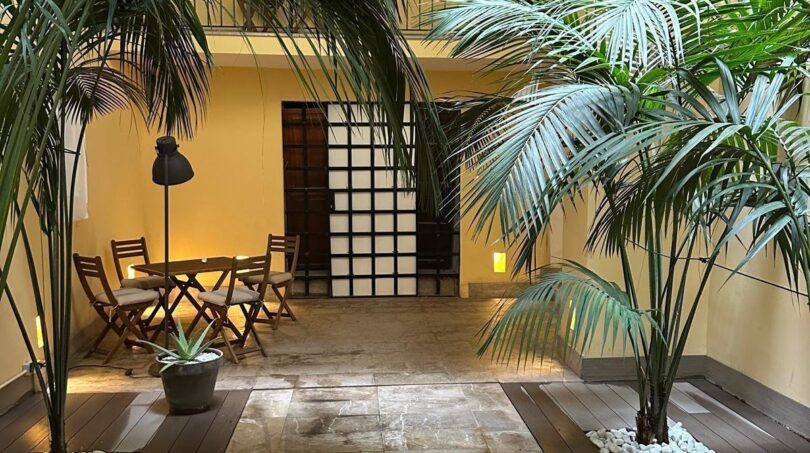 Elegante corte interior del apartamento en Palma con palmeras, suelo de piedra natural y acogedora zona de estar