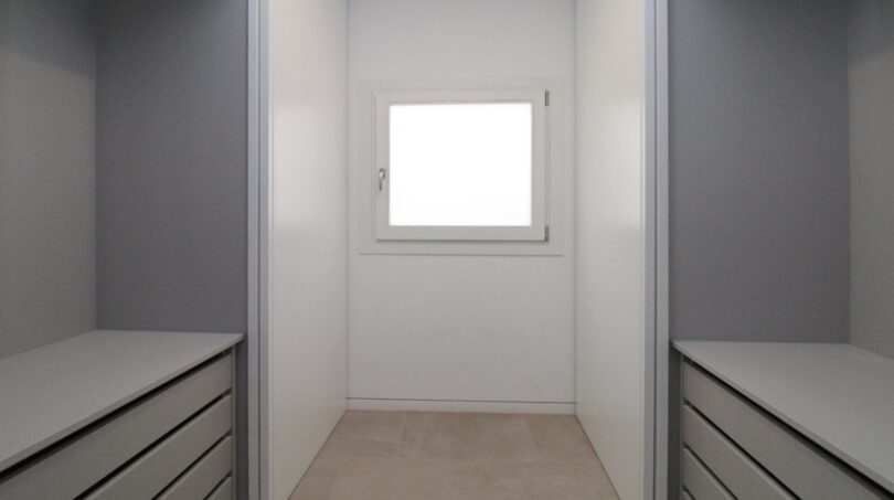 Vestidor incorporado moderno con cajones empotrados grises y ventana en el ático, Paseo del Borne, Palma