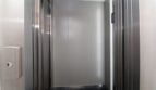 Ascensor moderno con puertas de acero inoxidable y cabina revestida en gris en el exclusivo ático del Paseo del Borne