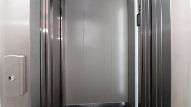 Ascensor moderno con puertas de acero inoxidable y cabina revestida en gris en el exclusivo ático del Paseo del Borne