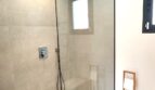 Modernes Badezimmer mit ebenerdiger Glasdusche, Regendusche und Holzboden im Einfamilienhaus Marratxí