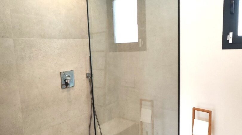 Modernes Badezimmer mit ebenerdiger Glasdusche, Regendusche und Holzboden im Einfamilienhaus Marratxí