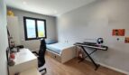 Jugendzimmer mit Schreibtisch, Gaming-Stuhl, Einzelbett, E-Gitarre und Keyboard im modernen Einfamilienhaus Marratxí.