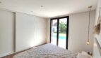 Helles Schlafzimmer mit Einbauschrank und Glastür zum privaten Pool in modernem Einfamilienhaus in Marratxí