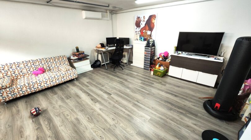Helles Wohnzimmer mit Laminatboden, Sofa, Schreibtisch, Flachbild-TV und Klimaanlage in Marratxí.