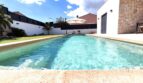 Privater Pool mit türkisblauem Wasser, Liegestühlen und Sonnenschirm im gepflegten Garten eines modernen Einfamilienhauses in Marratxí.