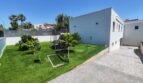 Gepflegter Garten mit Kunstrasen, Obstbäumen und Spielbereich neben modernem Wohnhaus in Marratxí