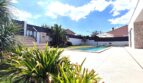 Gepflegter Außenbereich mit Pool, Liegestühlen und Sonnenschirm eines modernen Einfamilienhauses in Marratxí.