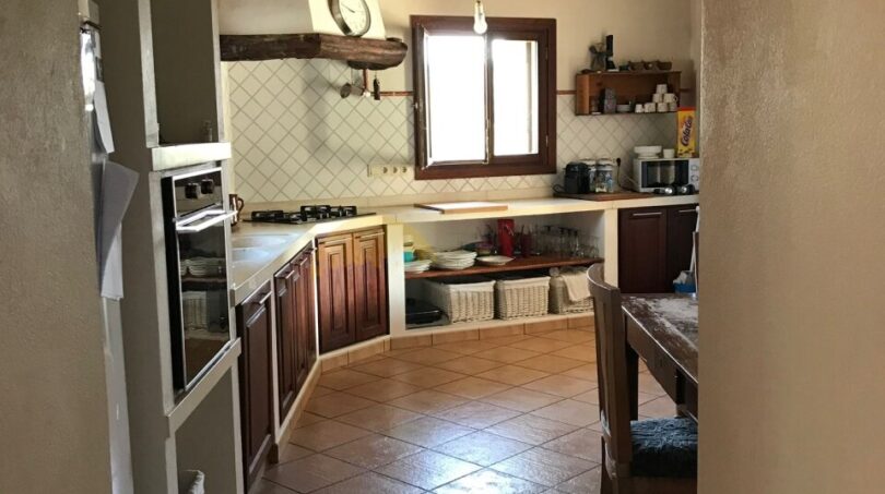 Rustikale Küche der Finca in Artà mit Holzbalkendecke, Terrakottaboden und Landhausküche