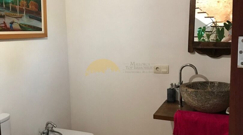 Rustikales Badezimmer der Finca in Artà mit Naturstein-Waschbecken, Bidet und dekorativer Wandmalerei
