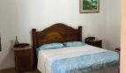 Gemütliches Schlafzimmer der Finca Artà mit Holzbalkendecke, Doppelbett und rustikalem Holzmobiliar.