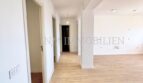 Heller, renovierter Wohnbereich mit Laminatboden, weißen Wänden und Blick in den Flur der Wohnung in Son Espanyolet.