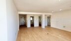 Helles, leeres Wohnzimmer mit Laminatboden und weißen Wänden in renovierter Wohnung in Son Espanyolet, Palma