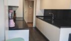 Moderne Küche mit weißen Fronten, dunkler Granitarbeitsplatte und rosa Mixer im Luxus-Apartment in Palma