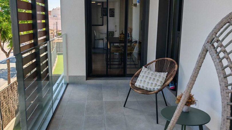 Moderner Balkon mit Rattanstühlen, Glasgeländer und Blick ins Wohnzimmer, Apartment Palma de Mallorca